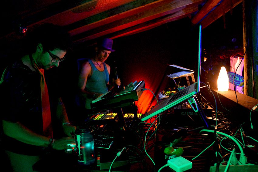 Summer DJs and Performers Participant holding a microphone next to another looking down at dj equipment